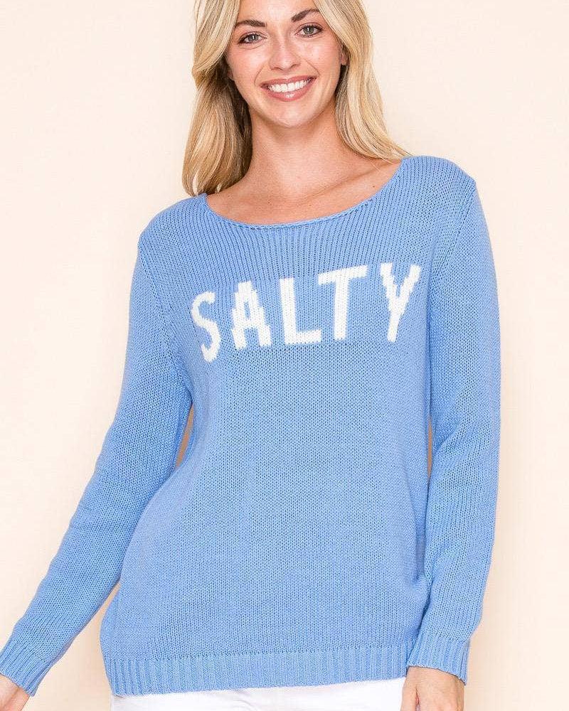 Woman wearing a blue sweater with 'SALTY' text on a beige background