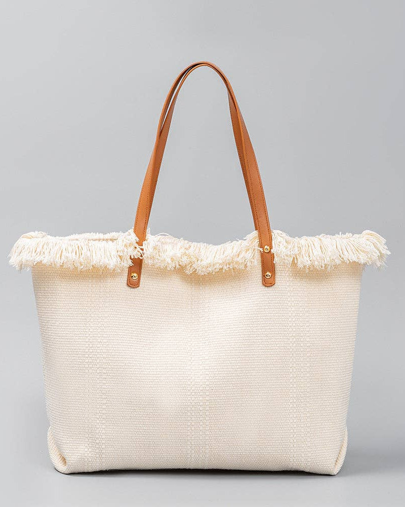 Beige tote bag with frayed edge and brown handles on a gray background