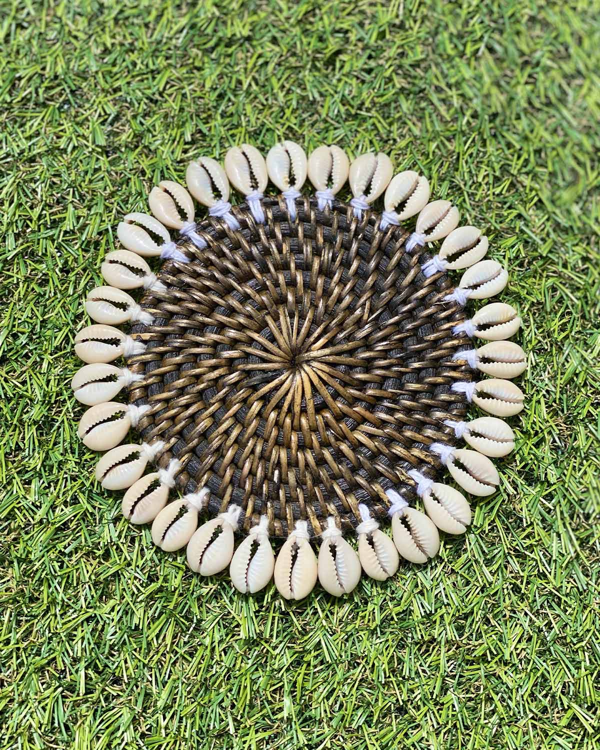 Rattan coaster painted black edged with sea shells.